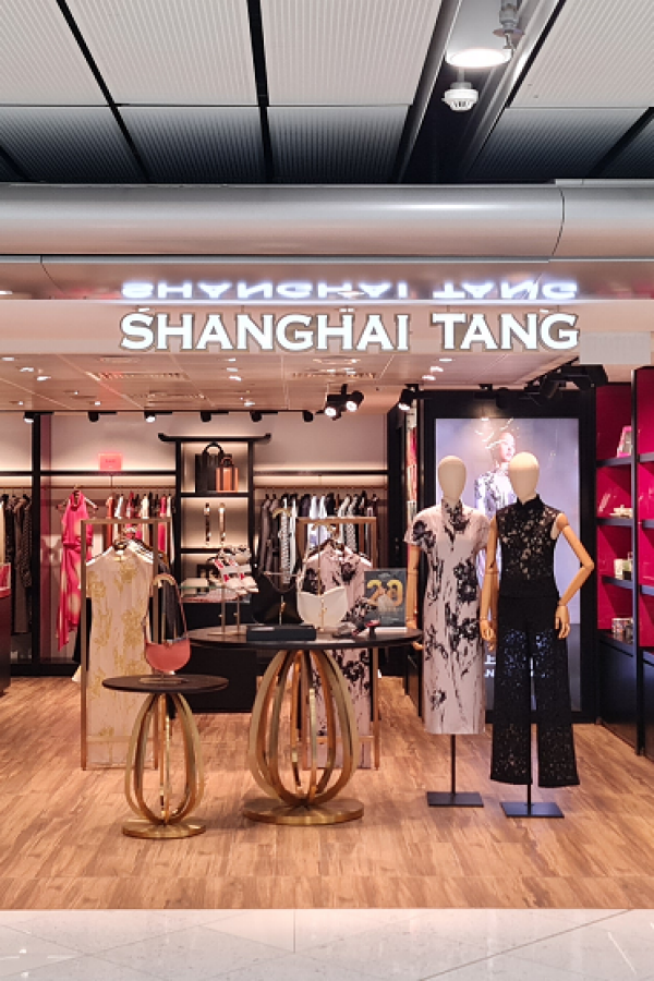 The storefront of Shanghai Tang at Hong Kong International Airport. Two manequins in Qipao are displayed near the shopfront. 