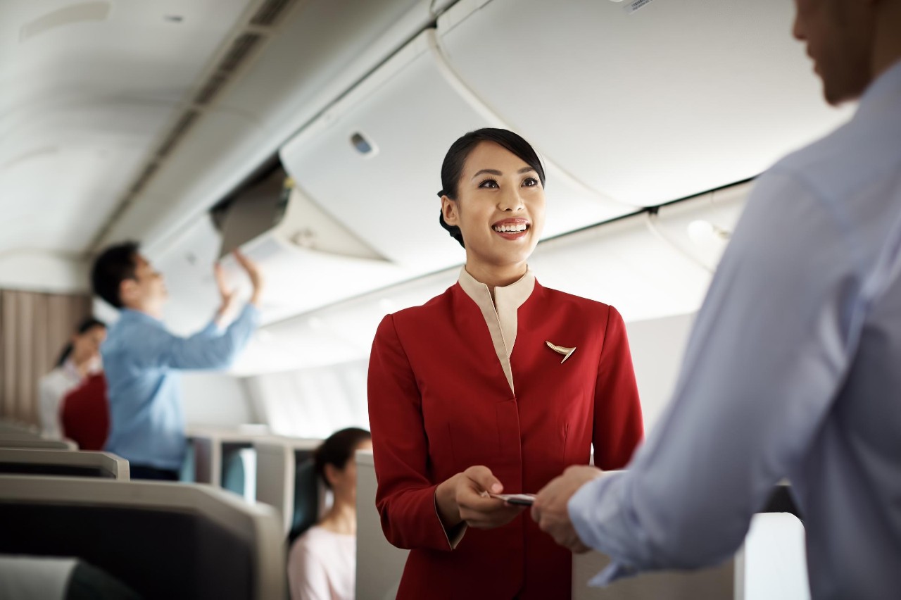 Flight attendant welcoming customer onboard